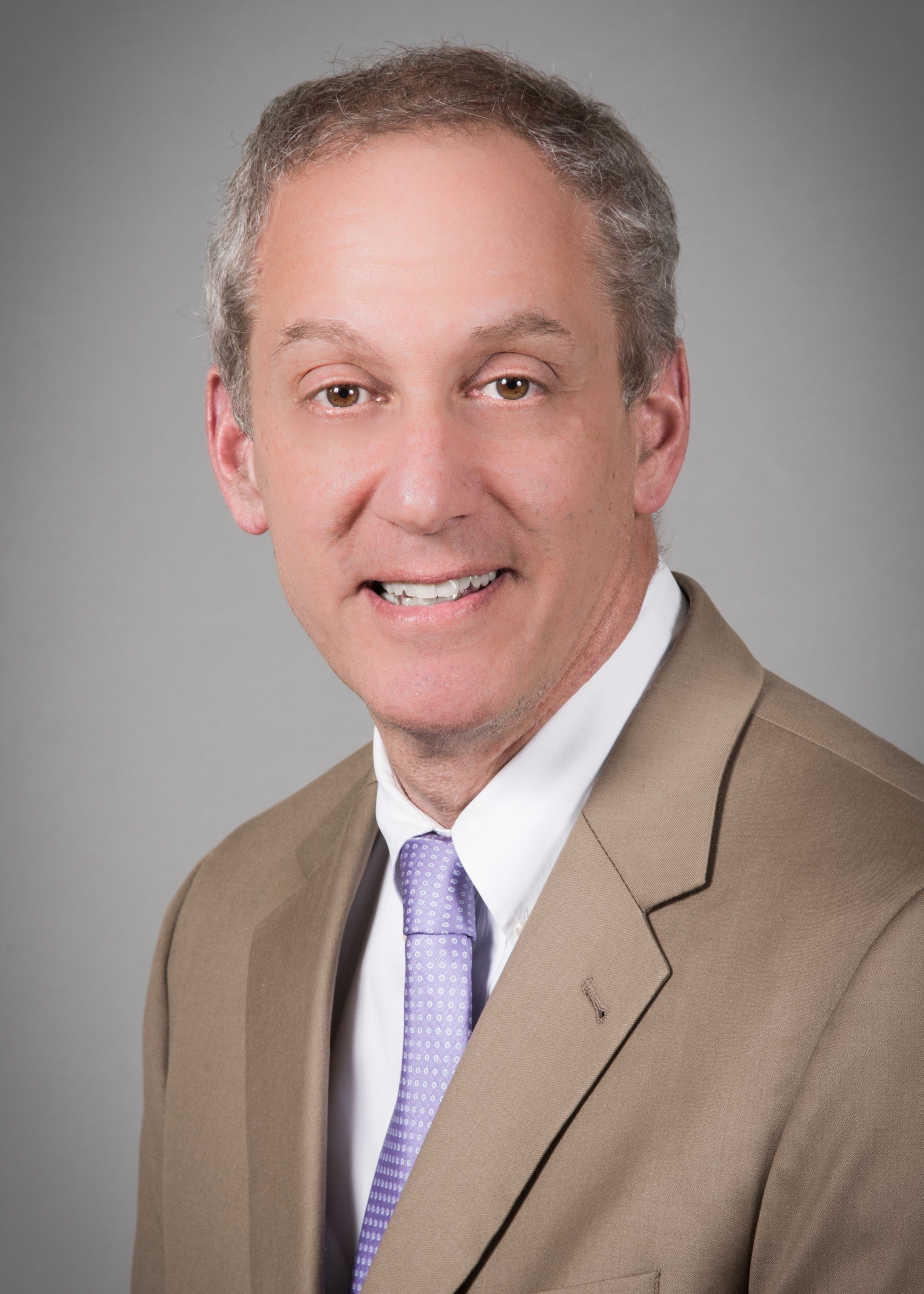 Peter Silver, MD, wearing a beige suit and purple tie